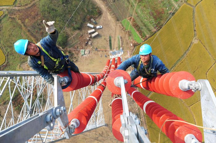 国网安徽电力施工人员在安徽芜湖市无为县的70多米高的瓷瓶串上施工。（郑贤列摄）